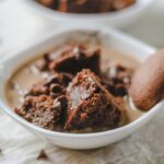 a white bowl filled with brownies and a cookie