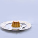 brown and white ceramic saucer with stainless steel spoon